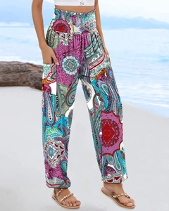Women's boho printed trousers with high elastic waist and pockets against a beach backdrop
