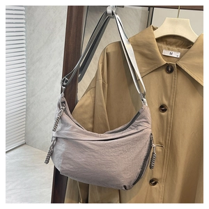 Detail of grey crescent shoulder bag with adjustable strap and textured nylon fabric