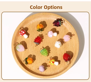 Detailed view of colorful fruit and mushroom charms in wooden tray for DIY jewelry