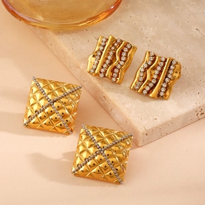 Vintage geometric gold earrings with zircon inlay on marble and glass background