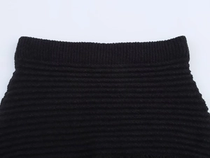 Dettaglio del tessuto a maglia nera con costine ad alta densità e cuciture in vita