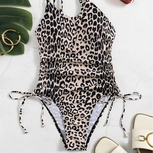 Leopard print one-piece swimsuit with side drawstrings and tropical vacation props