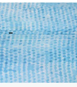 Detail of blue polka dot waterproof shower curtain showing precise stitching and fabric texture