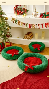 Detail eines Weihnachts-Haustierbetts mit grünem Vlies, rotem Kissen und Schleife
