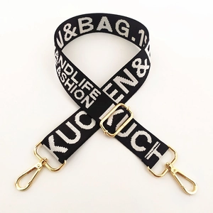 Detail of adjustable black and white letter print woven strap with gold metal hooks