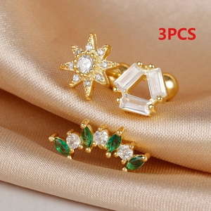 Close-up of three-piece gold starburst earring set with green and white zircon on silk