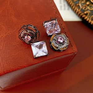 Macro detail of vintage floral earring with square zircon and colorful rhinestones