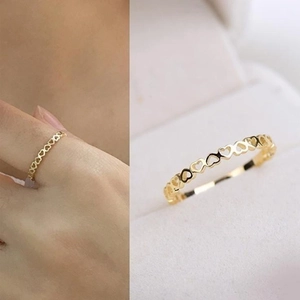 Detail of elegant gold hollow heart ring featuring a continuous openwork pattern design