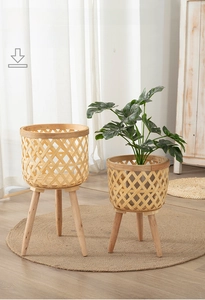 Set of two woven bamboo flower pot stands with solid wood legs in a minimalist room
