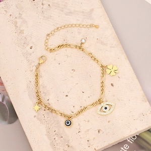 Detalle de pulsera de acero dorado con estrella turquesa y dijes de ojo turco
