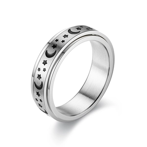 Detail of spinning stainless steel ring with engraved black moon and star patterns
