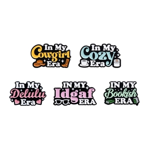 Set of five colorful enamel letter brooches featuring various 'In My Era' theme designs