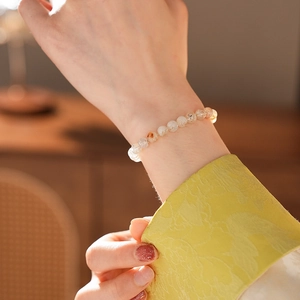 Gros plan d'un bracelet en perles de quartz jaune de 6mm porté sur le poignet