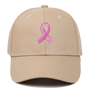 Detail of khaki cotton baseball cap featuring pink ribbon embroidery on the crown