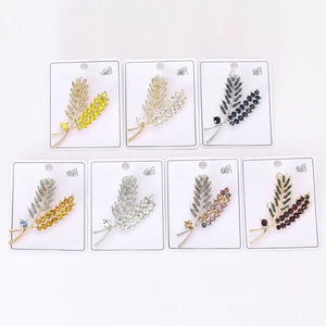 Macro shot of colorful rhinestone leaf brooches on cards showing exquisite crystal details