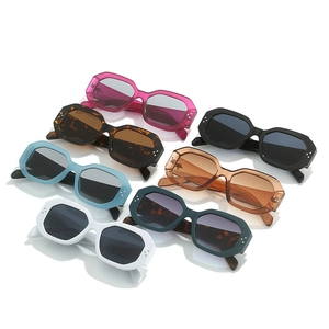 Flat lay of vintage geometric sunglasses with wide frames and triple rivet details