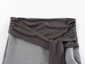 Detailed macro view of gray patchwork knit skirt showing drawstring waist and side zipper