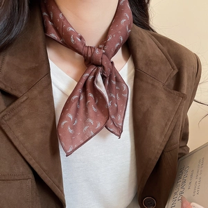 Detail of vintage brown paisley print silk scarf necklace styled with a blazer