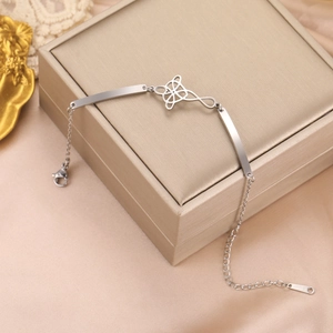 Detail of silver stainless steel bracelet featuring a hollow geometric knot and lobster clasp