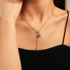 Close-up of a silver Y-shaped necklace featuring a sunflower pendant with tiger eye stone
