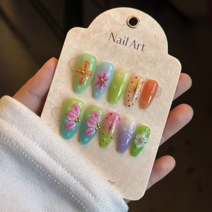 Detailed close-up of almond-shaped press-on nails with 3D floral relief and color gradients