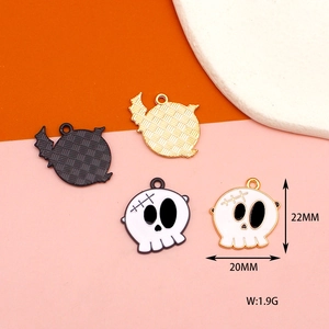 Detailed view of Halloween skull charms in black and white enamel with 22mm measurements