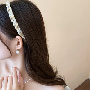 Détail d'un serre-tête en tweed avec chaîne dorée et boucles d'oreilles perles cœur
