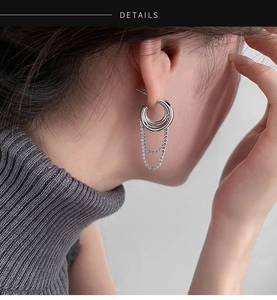 Detail of silver layered chain tassel earrings with sparkling cubic zirconia on a model