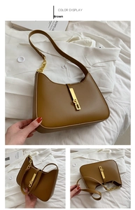 Detail of brown hobo bag with gold metal buckle and chain on white blazer backdrop
