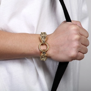 Macro view of golden double wolf head chain bracelet with ring clasp on male wrist