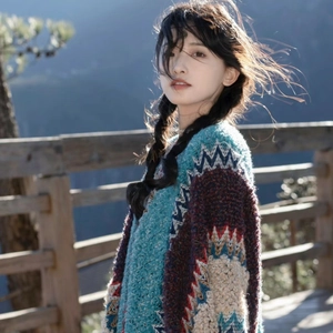 Detail of colorful ethnic knit shawl with geometric patterns and fringe on outdoor balcony
