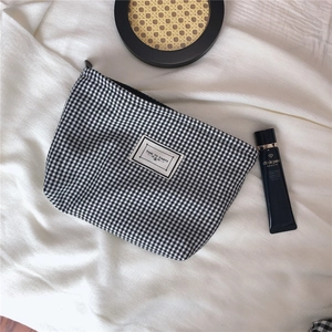 Close-up of black and white checkered cosmetic bag with Time to Party fabric label