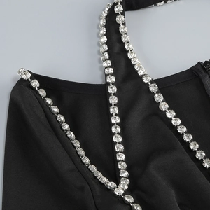 Detail of silver rhinestone chain on black V-neck cocktail dress for party