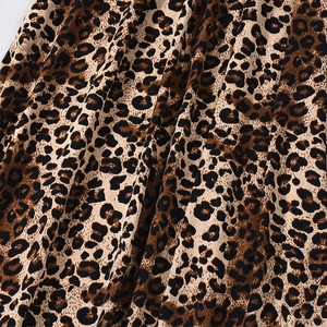 Detailed macro view of the leopard print fabric texture and flowing drape of the skirt