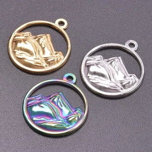Detailed view of circular mountain pendants in gold, silver, and rainbow 18K steel finish