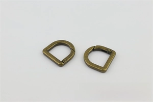 Macro detail of antique bronze D-ring spring clips for handbags, 20mm metal hardware