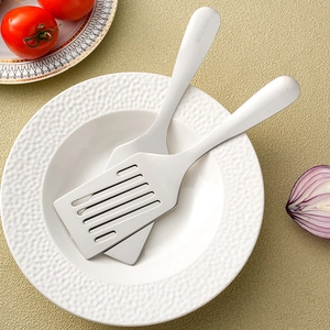 SUS 304 stainless steel kitchen spatula set with slotted turner on a white ceramic plate
