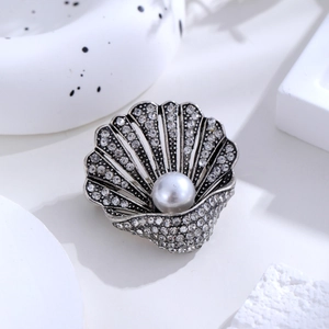 Macro shot of shell brooch with vintage silver finish, clear rhinestones and large pearl