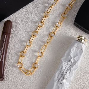 Detail view of 18K gold stainless steel chain necklace with white pearl accents