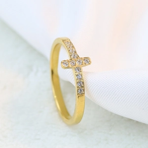 Macro detail of a 7mm gold-plated cross ring with sparkling white zircon stones