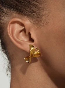 Close-up of a 18K gold-plated irregular twisted leaf earring worn by a female model