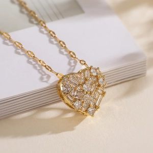 Collier luxe doré avec pendentif cœur serti de cristaux sur un livre blanc élégant