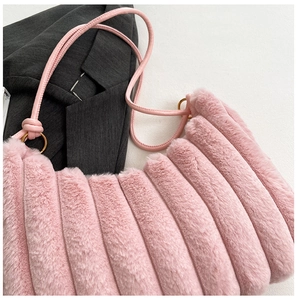 Dettaglio della borsa in peluche rosa con trama a righe ed eleganti anelli dorati