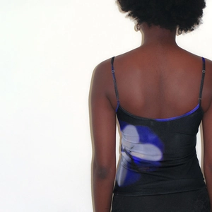 Detailed back view of a slim-fit black crop top with blue floral print and thin straps