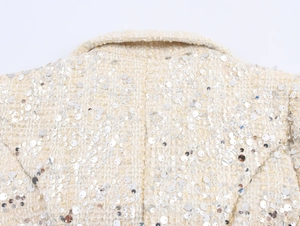 Gros plan sur le tissu en tweed blanc avec texture tissée et paillettes argentées au dos