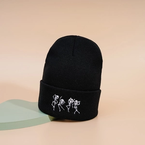 Bonnet en tricot noir avec squelettes dansants brodés en blanc sur un revers tendance