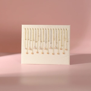 Elegant gold and silver necklace collection displayed on a beige fabric jewelry board