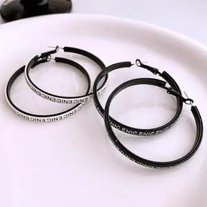 Minimalist black and white hoop earrings with bold letter print and silver needle posts