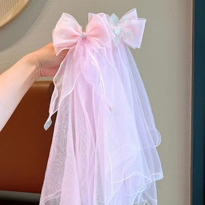 Detail of pink mesh veil hairpiece with sequins, bows and floral accents for girls