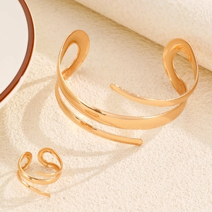Close-up of golden irregular winding leaf bangle and ring set with mirror finish